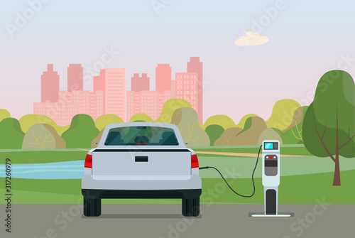 Fototapeta Naklejka Na Ścianę i Meble -  Electric pickup truck car on a background of cityscape. Electric car is charging, back view. Vector flat illustration.