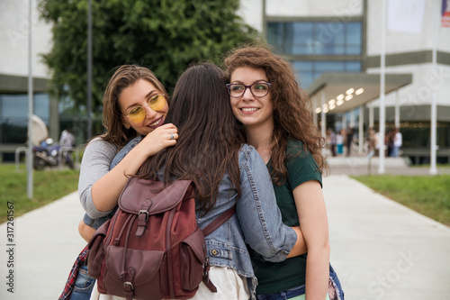 College girls hugging in front of a University campus