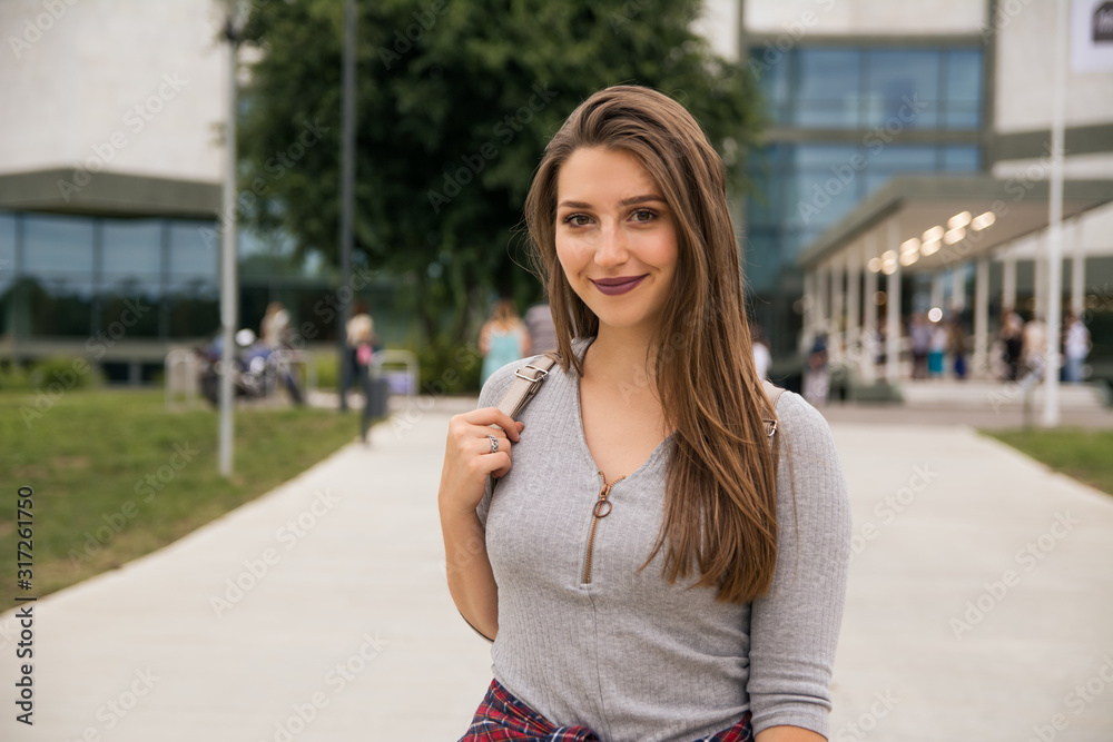 Portrait of a beautiful college girl in front of a University