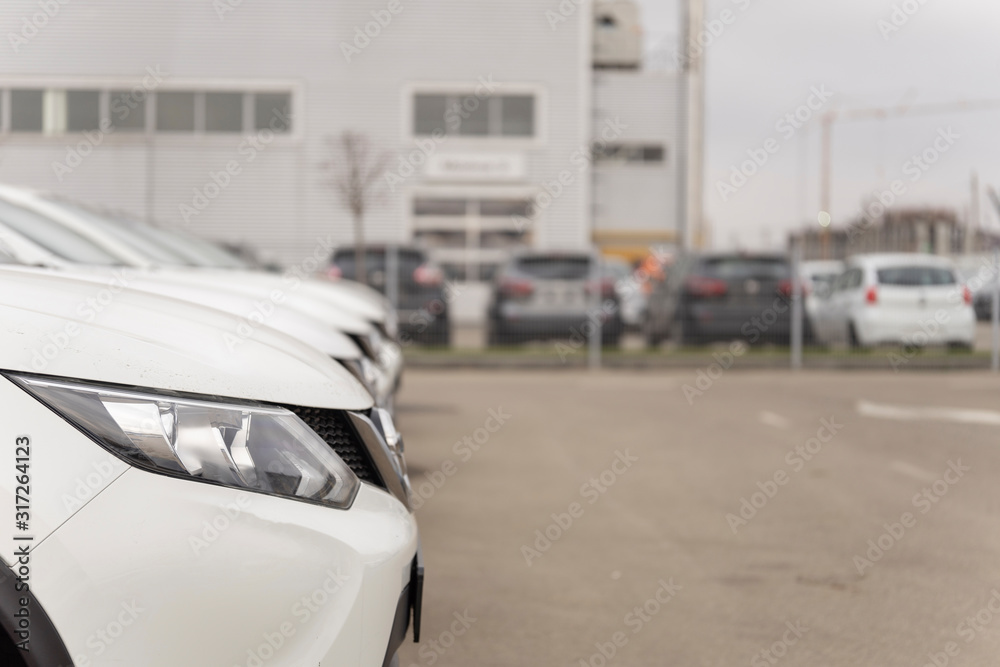 A row of used vehicles parked at a car dealership stock for sales