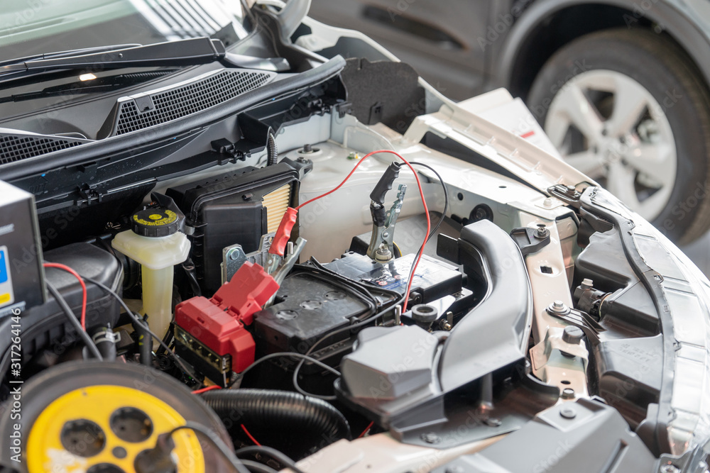 Fototapeta premium Process accumulator charging. Image of a car battery and jumper cables