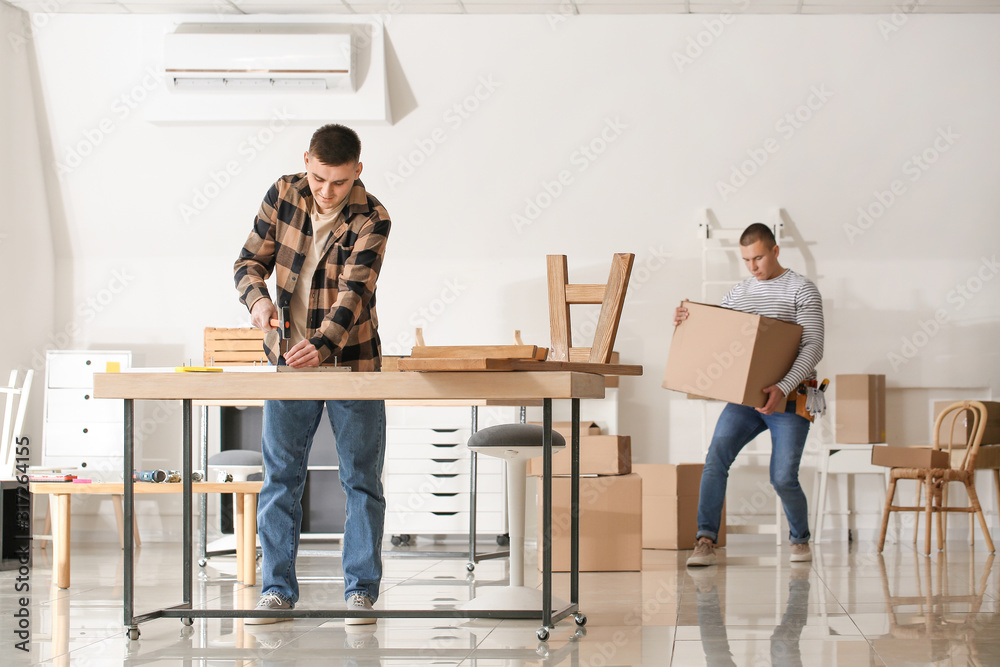 Handymen assembling furniture in workshop Handymen assembling furniture in workshop