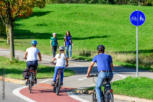 Radfahrer befahren einen Übergang von der Straße auf einen kombinierten Rad- und Fußweg photo