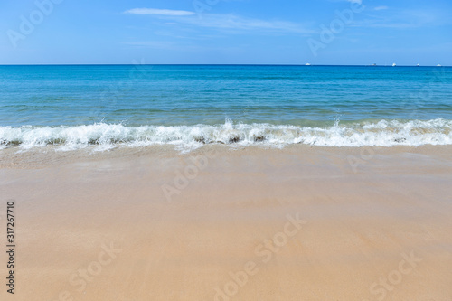 White wave on clean beach with beautiful summer blue sky and deep blue sea, holiday and vacation destination, seascape, nature concept background