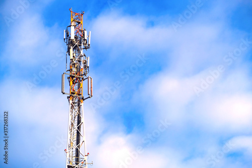 Antenna of the telecommunications tower. Communication network. Technology at the top of GSM telecommunications. Masts for mobile phone signal. Tower with cellular antennas on a blue sky background.