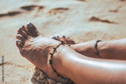 Women's feet on the sand. Concept of recreation and tourism.