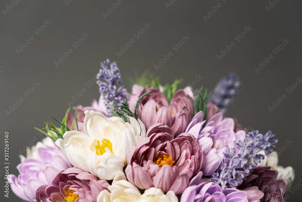 Fototapeta Flowers in bloom: Bouquet of lilac and pink wild flowers on a gray background.