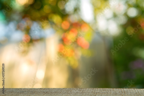 Empty wood table over blurred trees with bokeh background, product display montage