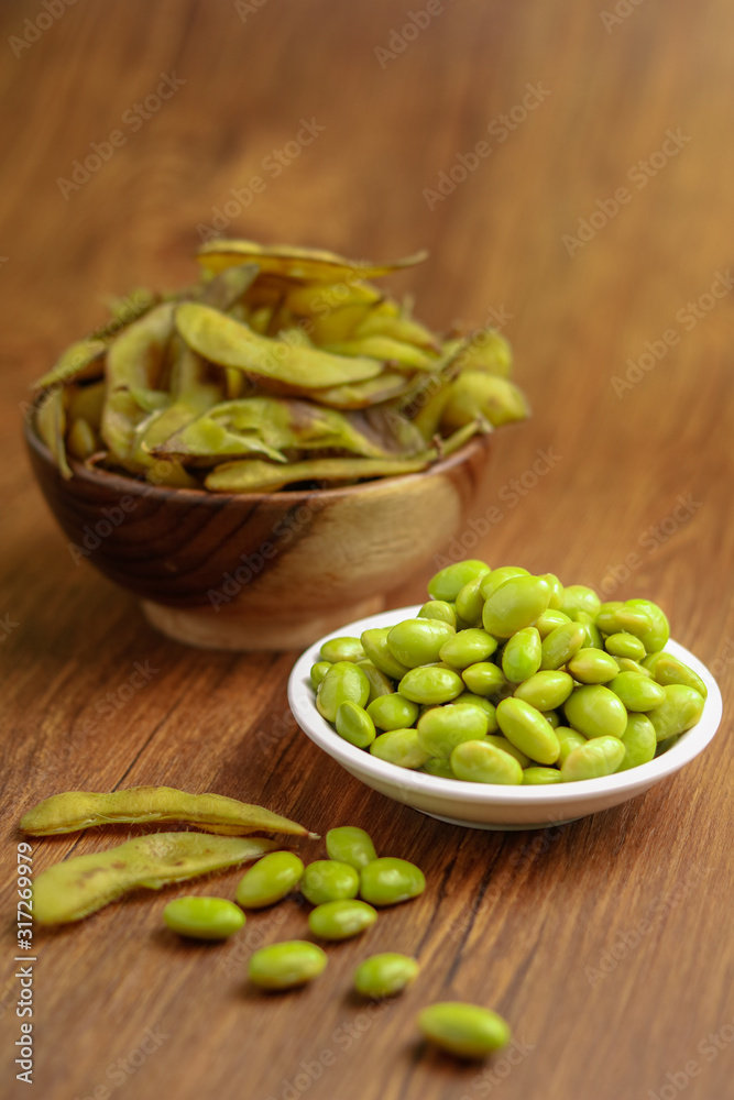 Edamame Beans Still lifeFresh boiled edamame beans isolated on wooden background Edamame Beans Still lifeFresh boiled edamame beans isolated on wooden background