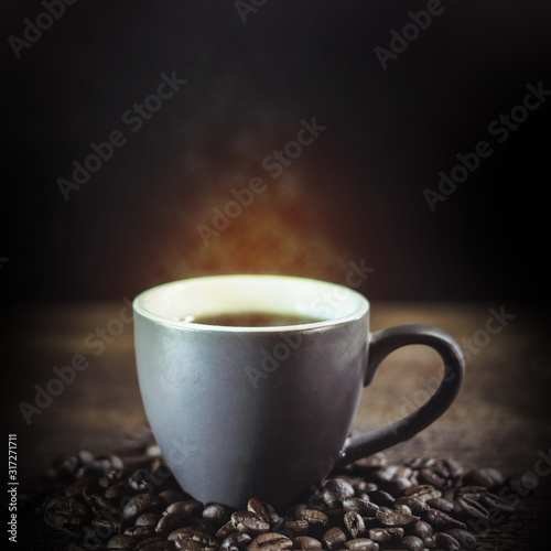 cup of coffee and coffee grains on a dark wooden background.