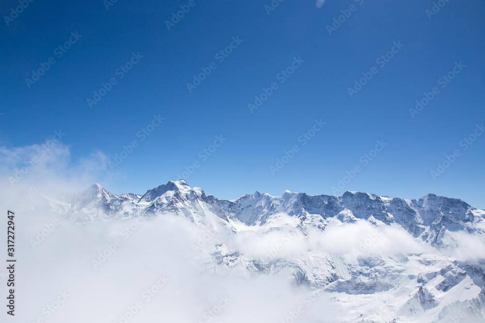 Winter landscape, Mountains covered by snow with mist flow through mountains in sunnyday winter in Switzerland