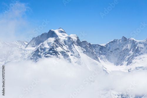 Winter landscape  Mountains covered by snow with mist flow through mountains in sunnyday winter with copy space in Switzerland