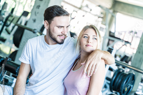 Couple men and women happy enjoying exercise in sport gym fitness club