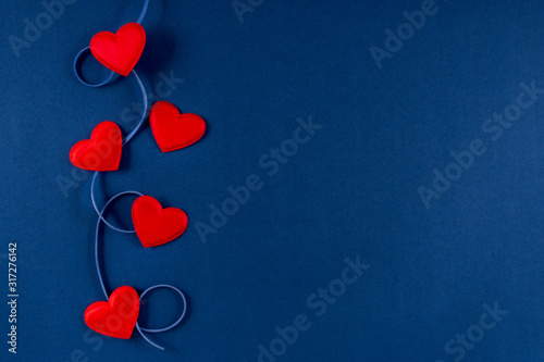 Red hearts with ribbon on classic blue 2020 color background. Valentines day 14 february concept. Flat lay, copy space, top view, banner. photo