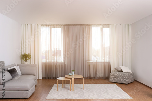 Windows with stylish curtains in living room interior