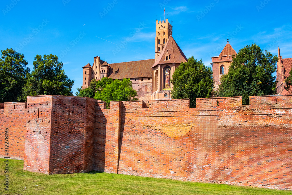 Panoramic view of the medieval Teutonic Order Castle in Malbork, Poland - High Castle and St. Mary church with the defense walls