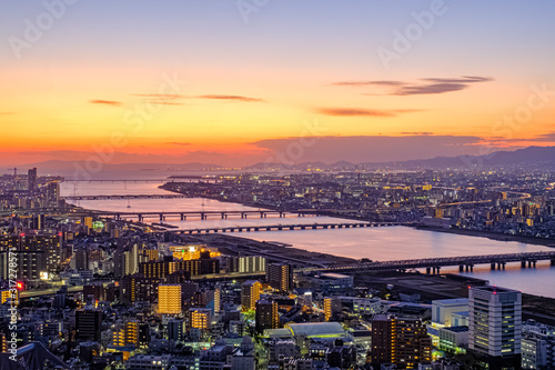Aerial sunset view of Osaka skyline with the river  citylight  and golden sky as seen from Umeda Sky Building.
