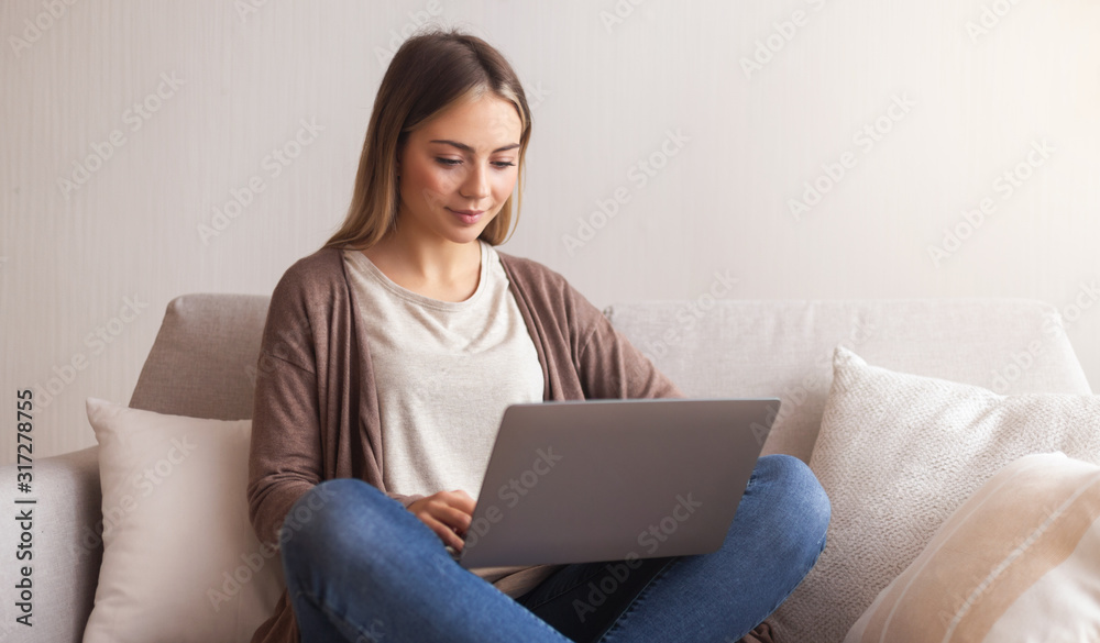 Charming millennial girl typing on laptop at home Charming millennial girl typing on laptop at home