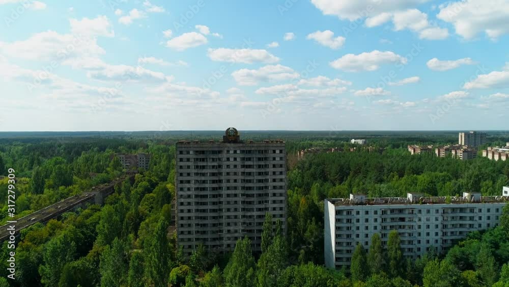 Aerial view of abandoned buildings and streets overgrown with trees in city Pripyat near Chernobyl nuclear power plant. Exclusion Zone. Camera approaching. Sign of USSR on the roof. 4K drone footage. Aerial view of abandoned buildings and streets overgrown with trees in city Pripyat near Chernobyl nuclear power plant. Exclusion Zone. Camera approaching. Sign of USSR on the roof. 4K drone footage.
