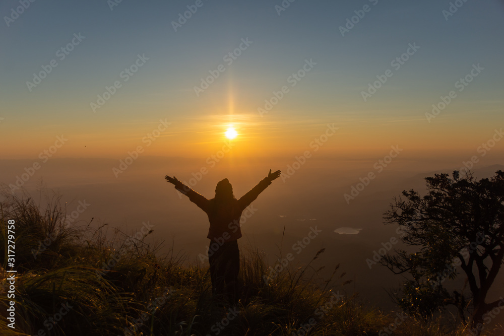 Fototapeta premium rear of happy woman stand on top mountain looking view with sunrise and mist at (Doi Norg Doi Luang National Park) Phayao province. soft focus.