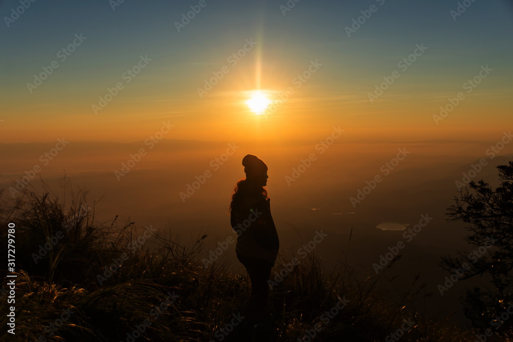 rear of happy woman stand on top mountain looking view with sunrise and mist at  (Doi Norg Doi Luang National Park) Phayao province. soft focus.