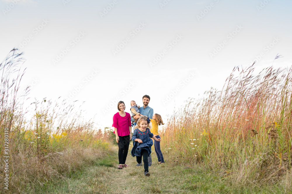 Young happy family walking outdoors in a field Young happy family walking outdoors in a field
