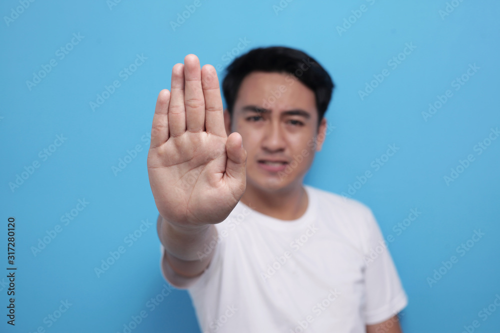Young Man Shows Stop Gesture with Selective Focus Young Man Shows Stop Gesture with Selective Focus