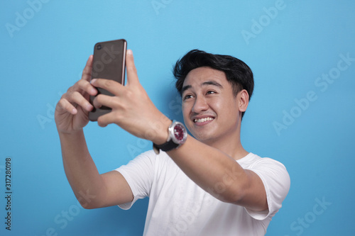 Happy young man taking selfie photograph by phone