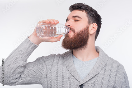 Stay Hidrate. Young man is drinking water from a plastic bottle.