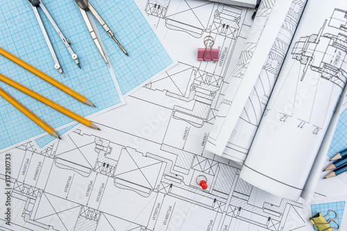 Technical drawing, graph paper and tools. Engineer office team working with blueprints © RomanR