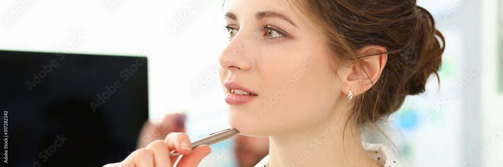 Obraz premium Portrait of gorgeous female working in big modern office and looking away with concerns and calmness. Pretty brunette holding pen in tender arm. Company meeting concept