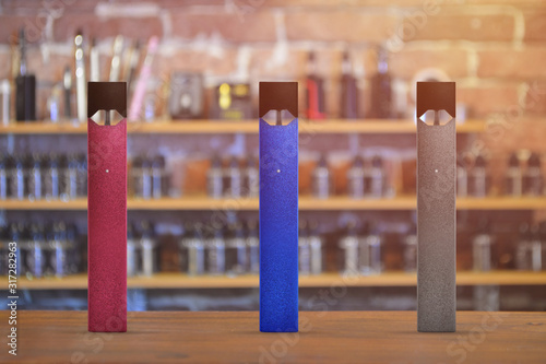 Electronic cigarette on a background of vape shop. E-cigarette for vaping. Popular vape devices photo