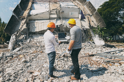 Demolition control supervisor and contractor discussing on demolish building.