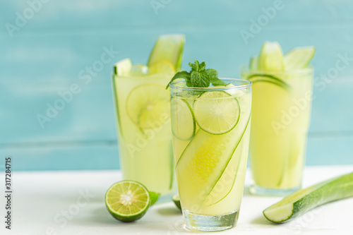Cucumber juice mix lime in a glass on a white wooden floor in a light blue background, summer drinks nonalcoholic