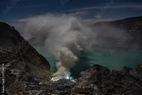 Ijen volcano crater and sulphur mining at the night. East Java, Indonesia
