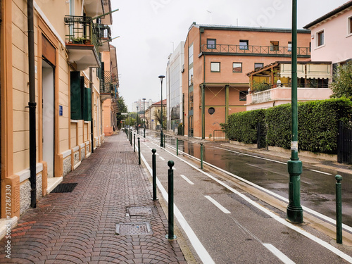 The Bike Lane with cobblestone sidewalk and road in the rain