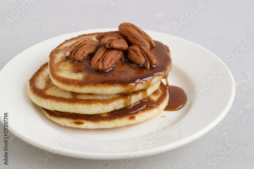 pancakes with caramel syrup and pecans.