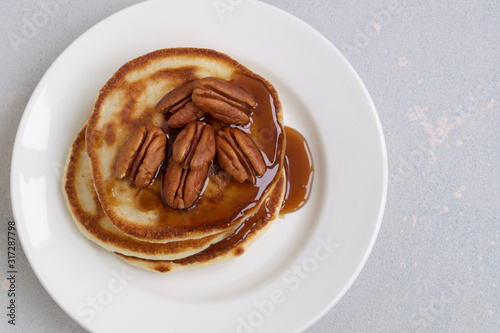 pancakes with caramel syrup and pecans.
