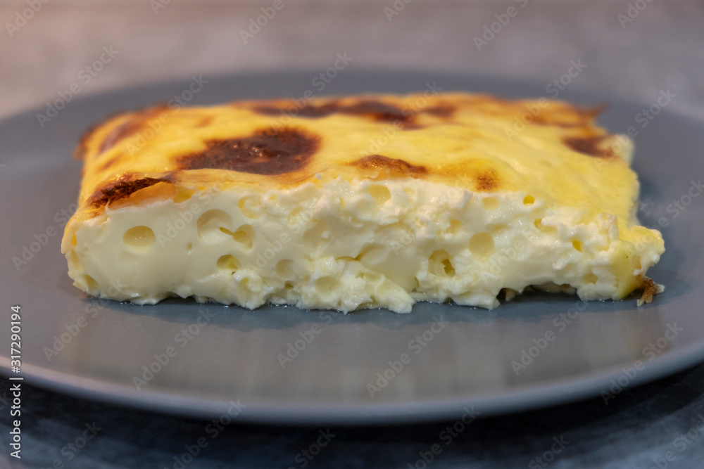 Exquisite egg and cheese casserole on a grey plate Exquisite egg and cheese casserole on a grey plate