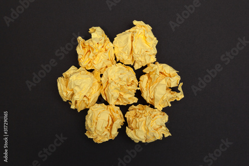 Crumpled paper balls on a black background. View from above.
