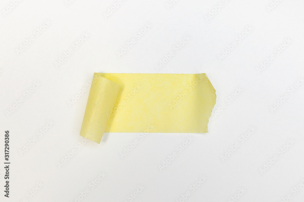 One horizontal adhesive paper tape of a yellow colour  on a white background.