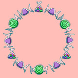 Round frame made of green, purple and jelly beans candies on pink background
