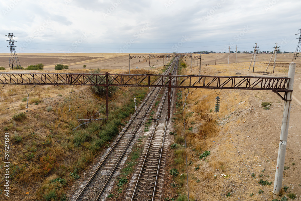 The railway in steppes of Kazakhstan, view of the rails from the bridge