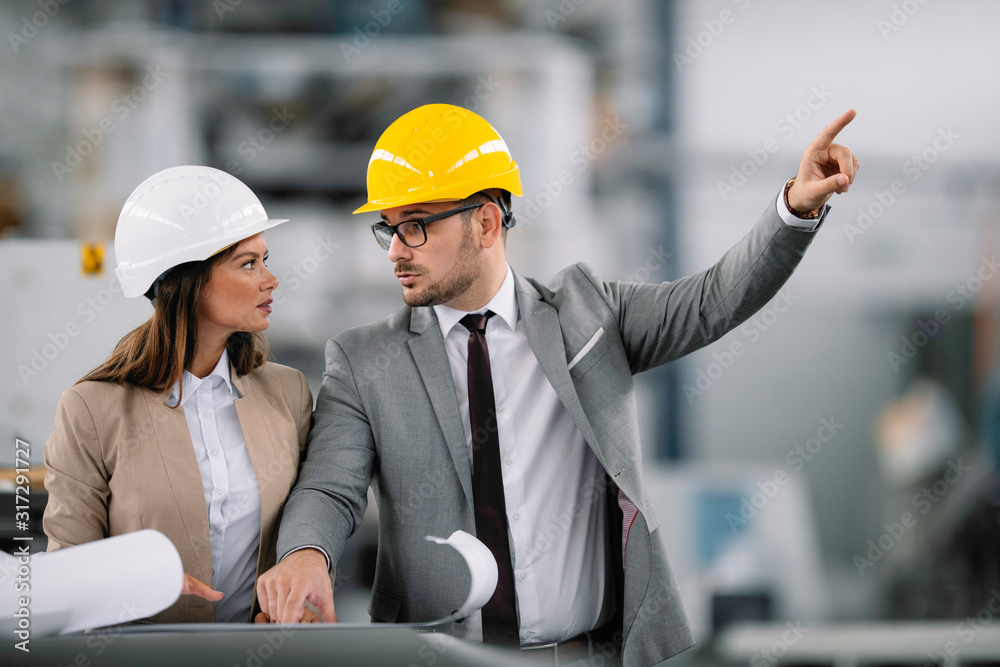 Architects working on construction project. Man and woman discussing work. Architects working on construction project. Man and woman discussing work.