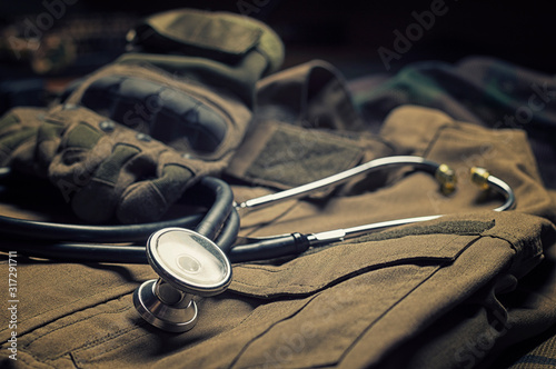 Stethoscope lies on the uniform of a US soldier. The concept of health care, military insurance, state care. Top view.