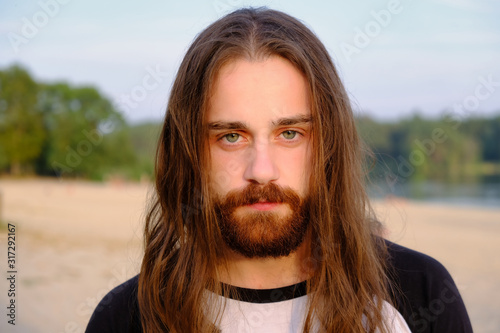 Portrait of handsome bearded young man with long hair photo