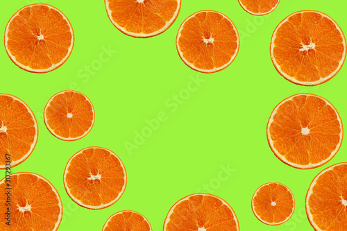 set with juicy slices of orange on a green background for a menu or recipe, the concept of vegetarian, vitamin and healthy food, background, pattern for textile, wallpaper, copy space