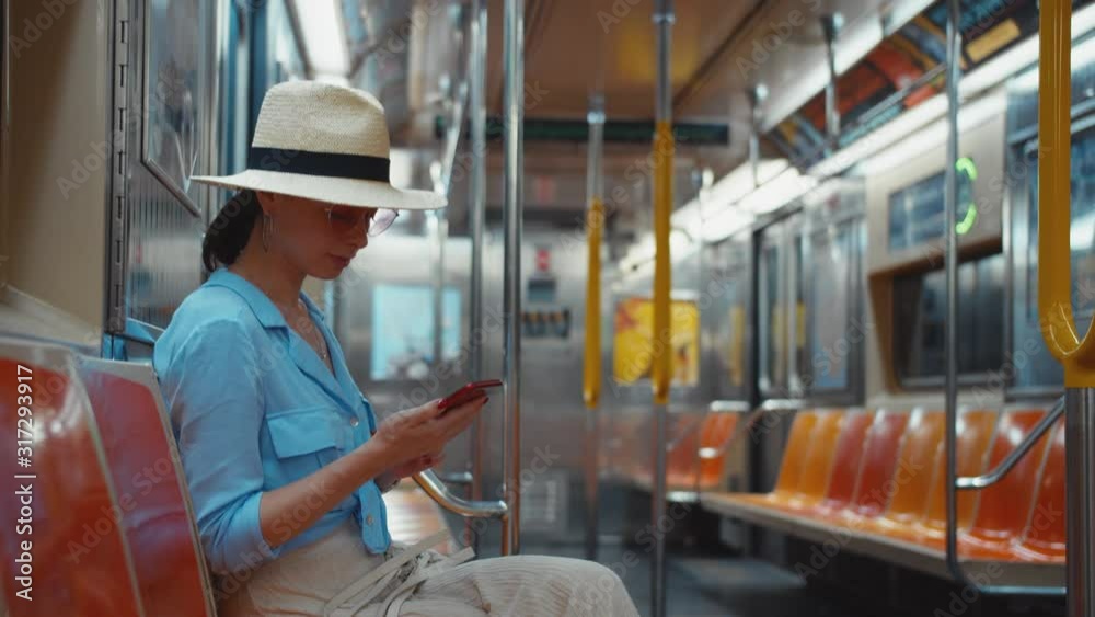 Young woman messaging in a subway train, NYC Young woman messaging in a subway train, NYC