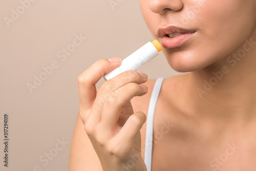 lips care and protection. woman applying balm on lips photo