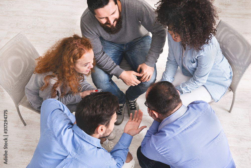 Diverse young people sitting in circle discussing working plan, top view Diverse young people sitting in circle discussing working plan, top view